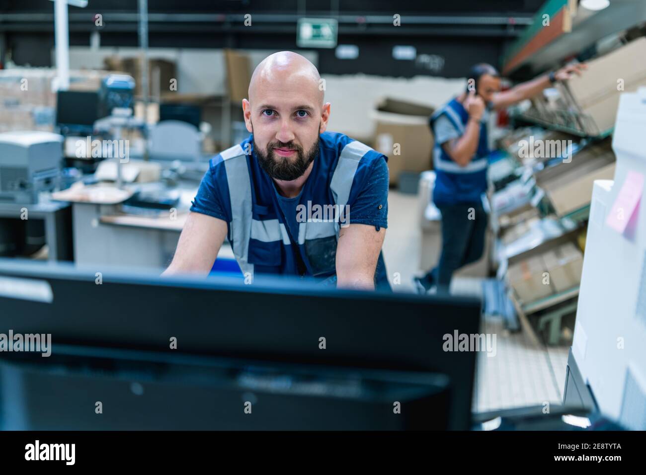 commissionatore di 30 anni che lavora su un computer a. il magazzino Foto Stock