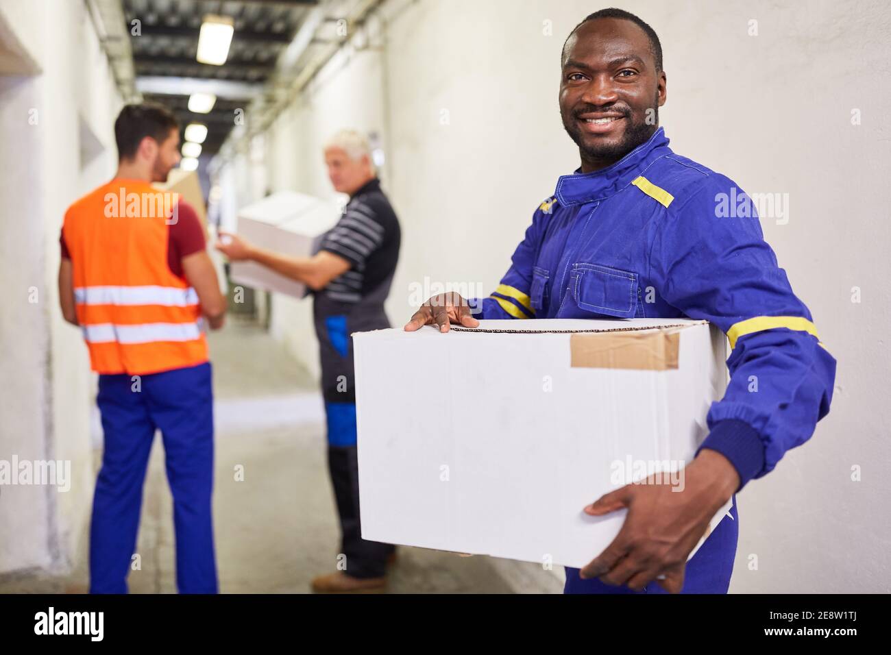 Lavoratore africano come lavoratore temporaneo o mini-jobber porta pacchetto al magazzino Foto Stock