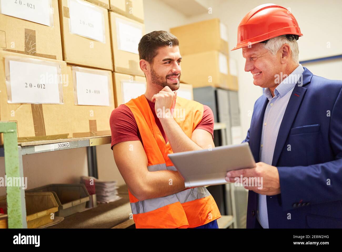 Imprenditore e impiegato di magazzino con un computer tablet prima della spedizione nel commercio in linea Foto Stock