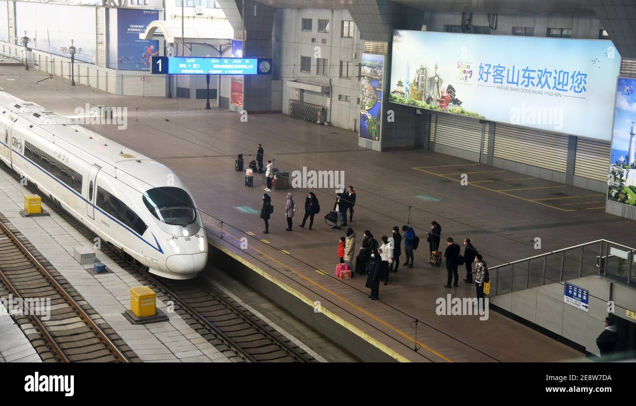 Jinan, provincia cinese di Shandong. 1 febbraio 2021. I passeggeri aspettano di salire a bordo del treno alla stazione ferroviaria di Jinan, nella provincia di Shandong della Cina orientale, 1 febbraio 2021. Il numero di viaggi in treno per passeggeri ha fatto un'immersione nei primi giorni della stagione di 40 giorni del festival primaverile, in mezzo a severe misure di controllo epidemico, i dati provenienti dall'operatore ferroviario nazionale hanno mostrato. Credit: Wang Kai/Xinhua/Alamy Live News Foto Stock