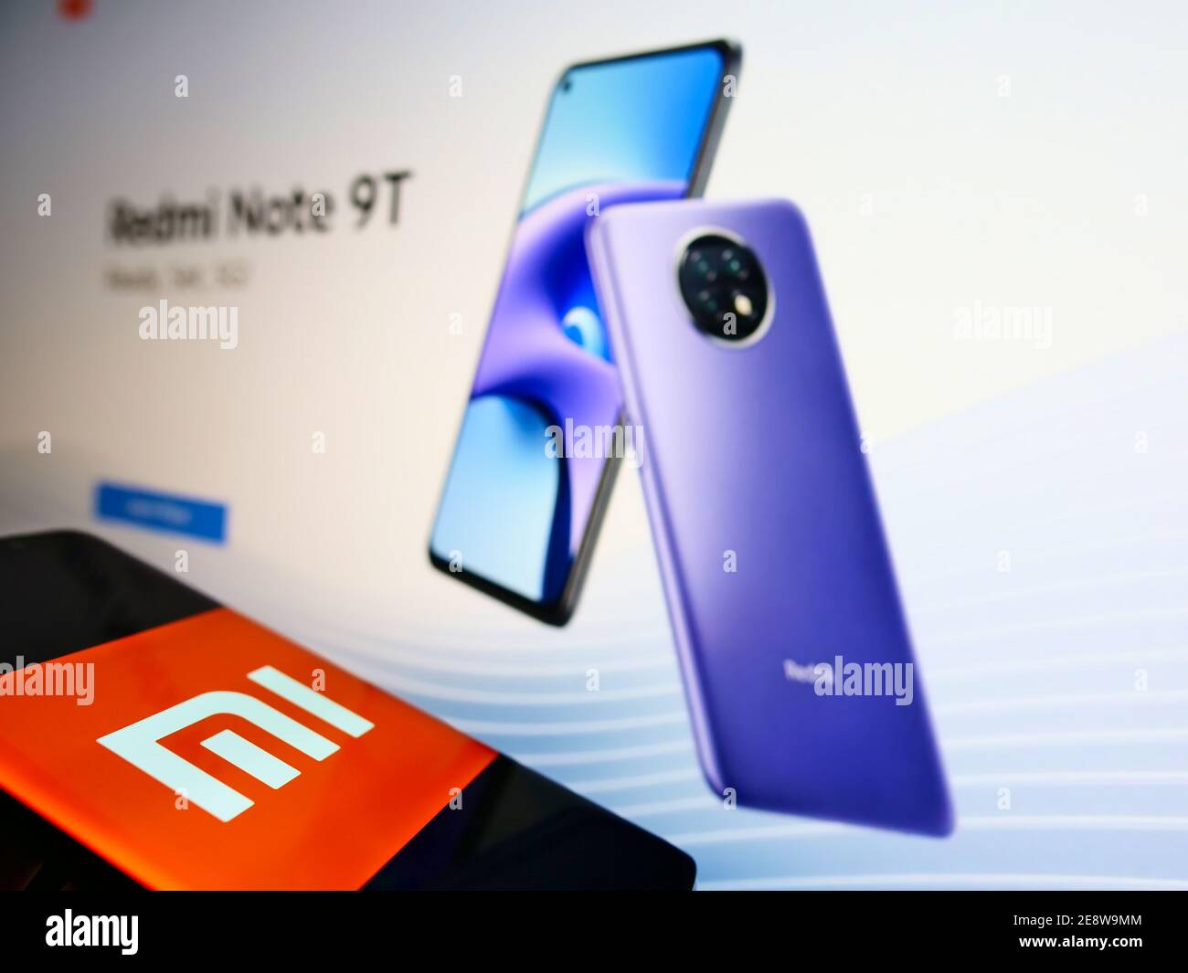 Telefono con logo aziendale del produttore cinese di smartphone Xiaomi Corporation in esposizione davanti al sito Web dell'azienda. Mettere a fuoco lo schermo del telefono cellulare. Foto Stock