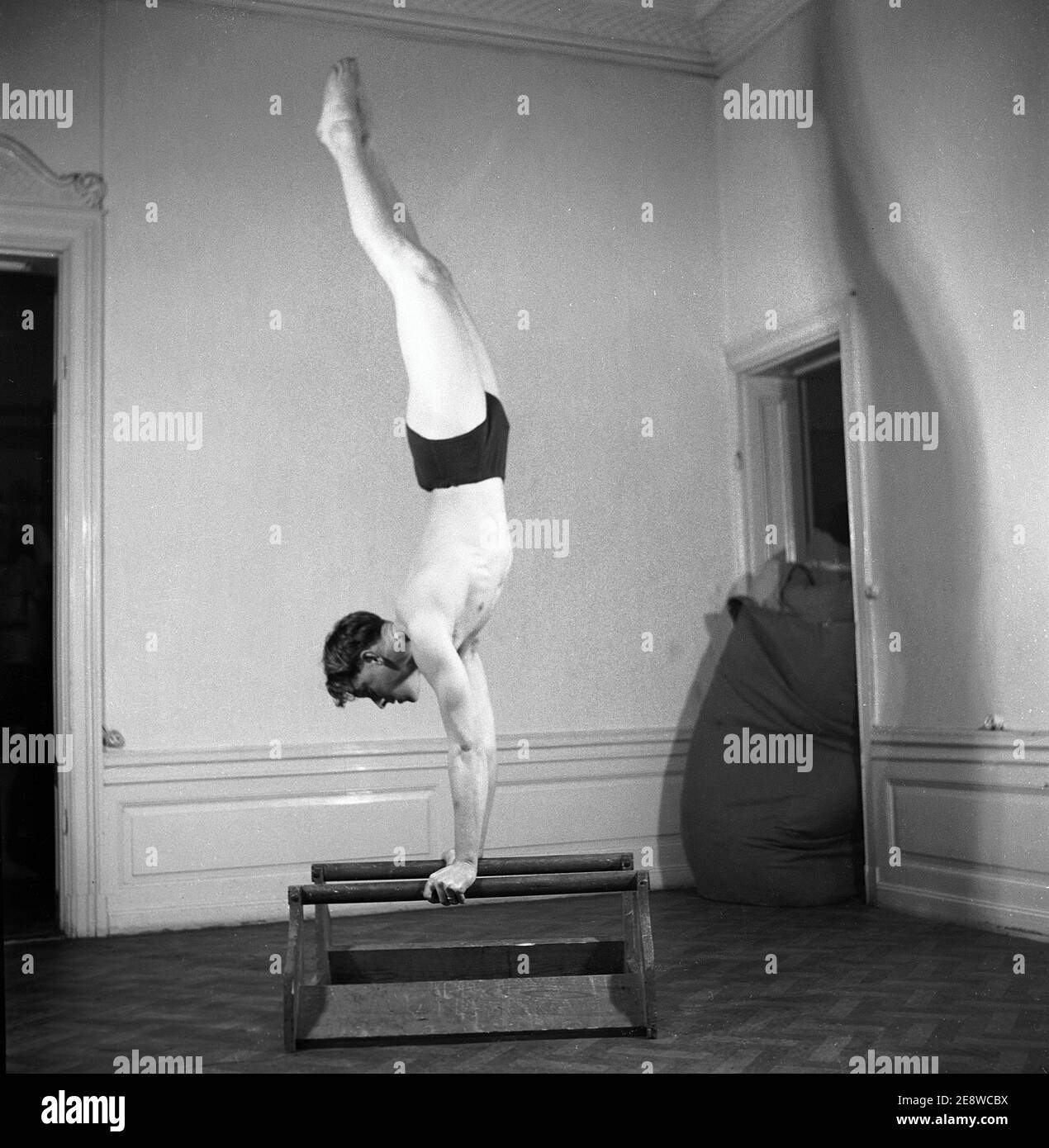 Uomo negli anni '40. Un giovane uomo forte e ben equilibrato sta in piedi capovolto sulle sue mani. È perfettamente straigt nel suo corpo quando tiene il suo proprio peso. Svezia 1945. Kristoffersson rif L115-5 Foto Stock