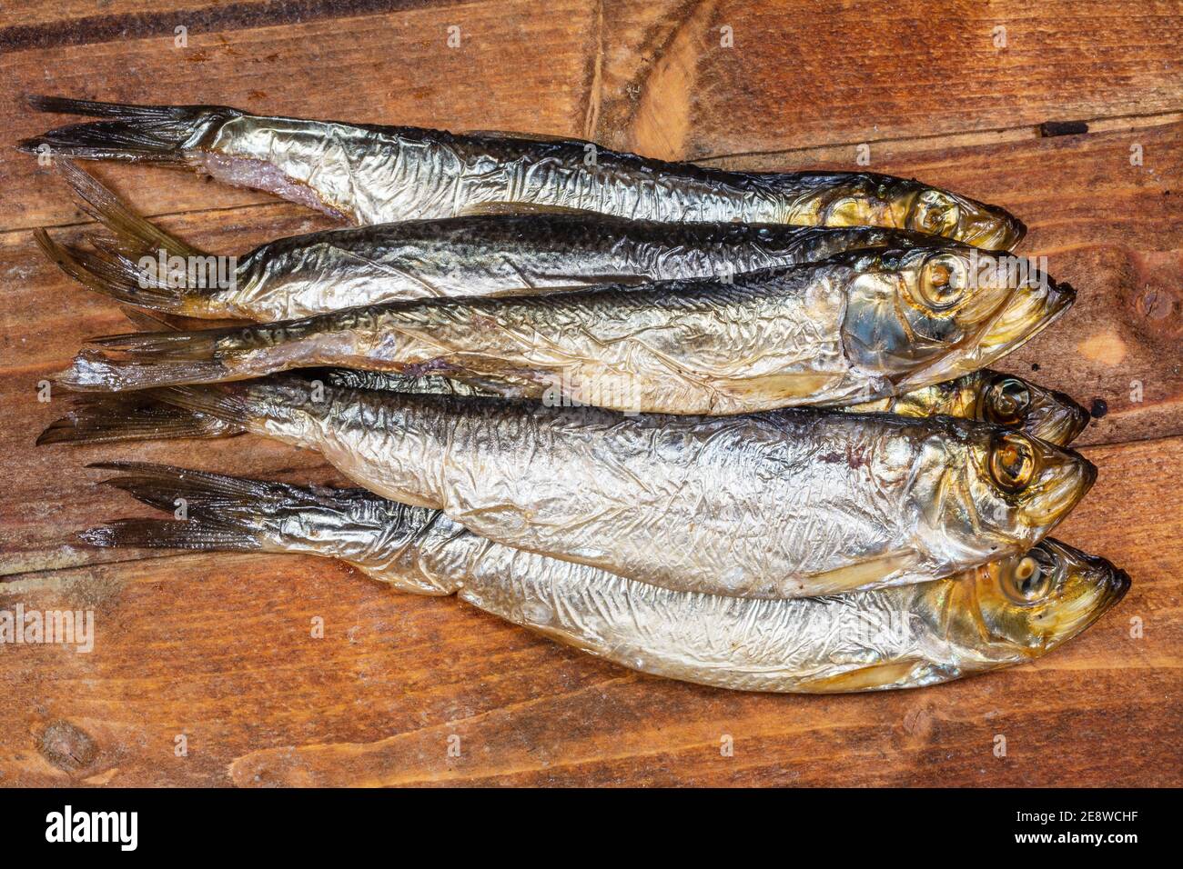 Aringhe baltiche affumicate (Clupea harengus membra) su un vecchio tavolo di legno Foto Stock