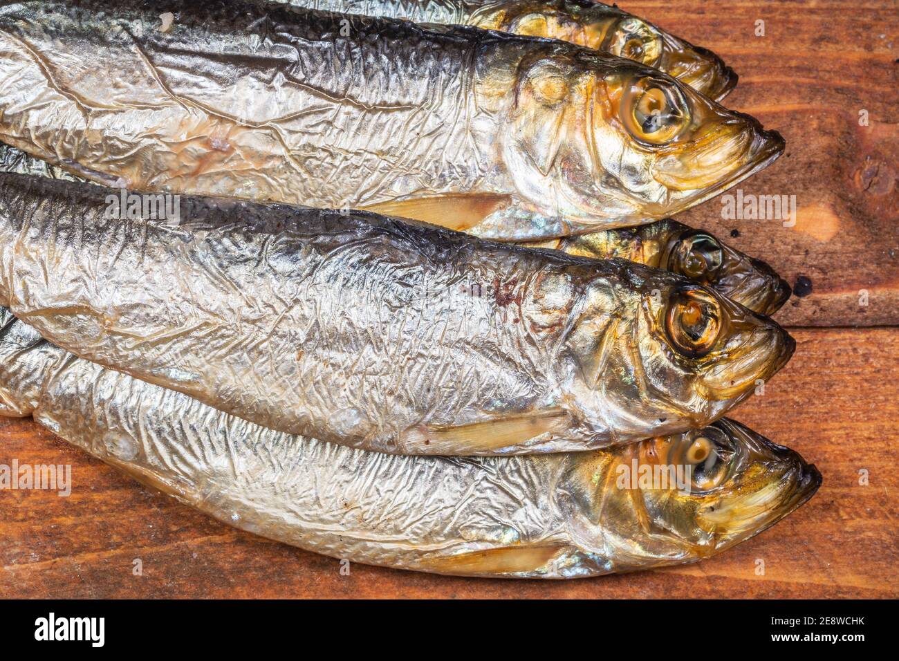 Aringhe baltiche affumicate (Clupea harengus membra) su un vecchio tavolo di legno Foto Stock