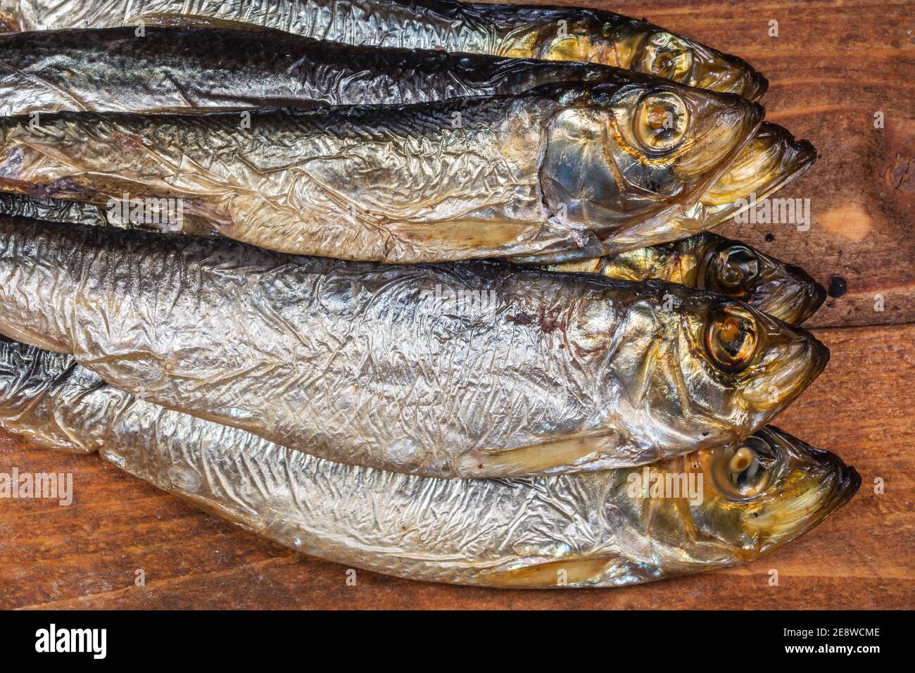 Aringhe baltiche affumicate (Clupea harengus membra) su un vecchio tavolo di legno Foto Stock