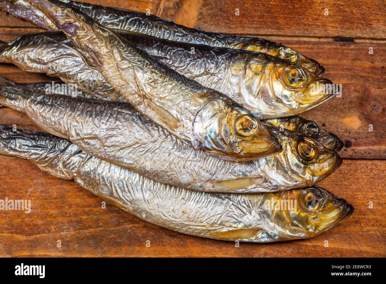 Aringhe baltiche affumicate (Clupea harengus membra) su un vecchio tavolo di legno Foto Stock