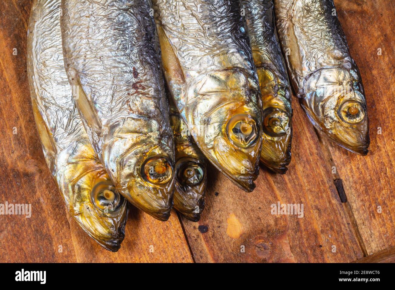 Aringhe baltiche affumicate (Clupea harengus membra) su un vecchio tavolo di legno Foto Stock