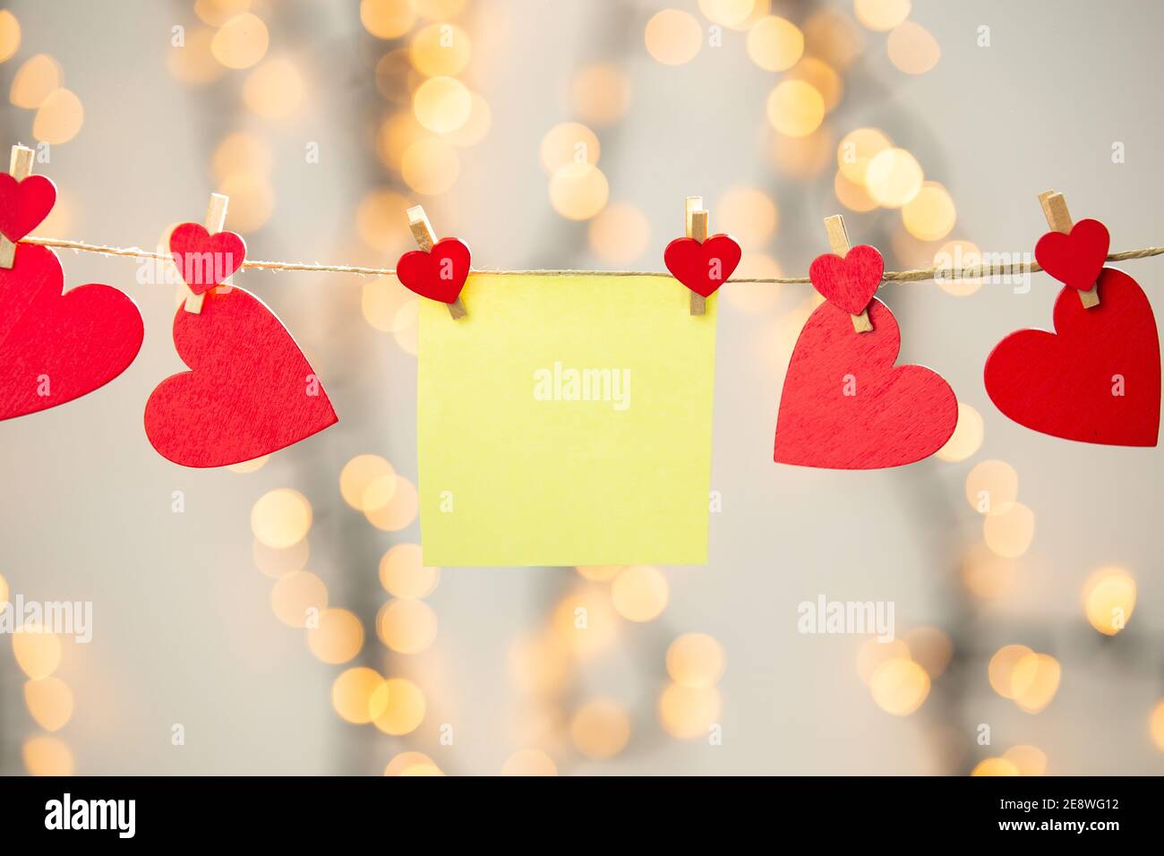 Bianco giallo appeso con cuori rossi con sfondo bokeh, romantico giorno di San Valentino sfondo spazio di copia di concetto Foto Stock