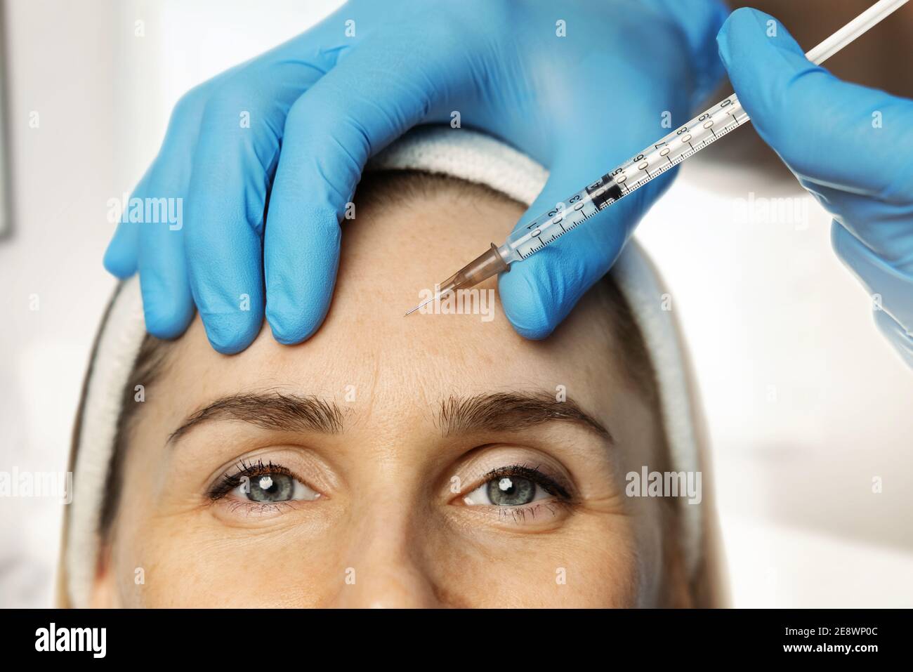 donna che ottiene l'iniezione cosmetica in fronte per ridurre le rughe Foto Stock