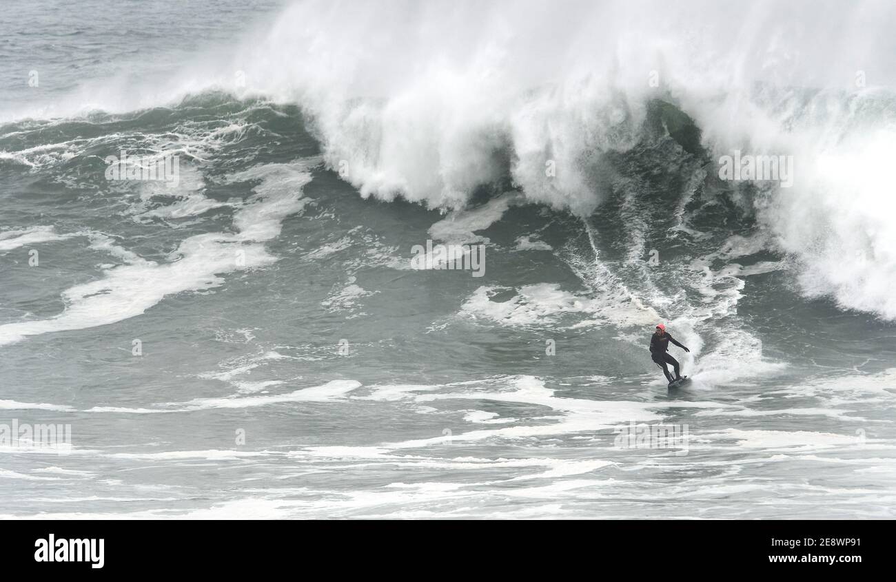 Newquay, Cornovaglia, 1 febbraio 2021. Meteo nel Regno Unito: Devon e Jeff Thomas, benzina power surf. La polizia della Cornovaglia ha costretto a chiudere l'enorme parcheggio della spiaggia di Towan Head Fistral dopo che centinaia di spettatori sono arrivati per vedere lo spettacolo delle onde più grandi in molti anni essendo guidato da un pilota di sufboard motorizzato. Credit: Robert Taylor/Alamy Live News" Foto Stock