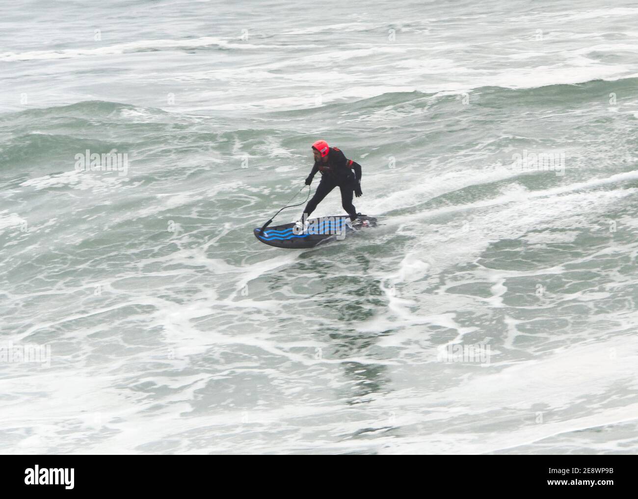 Newquay, Cornovaglia, 1 febbraio 2021. Meteo nel Regno Unito: Devon e Jeff Thomas, benzina power surf. La polizia della Cornovaglia ha costretto a chiudere l'enorme parcheggio della spiaggia di Towan Head Fistral dopo che centinaia di spettatori sono arrivati per vedere lo spettacolo delle onde più grandi in molti anni essendo guidato da un pilota di sufboard motorizzato. Credit: Robert Taylor/Alamy Live News" Foto Stock