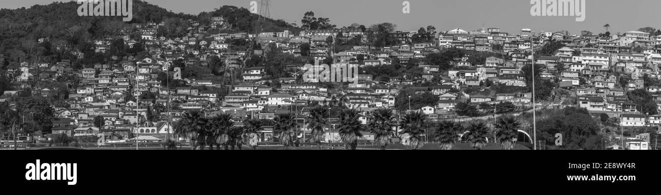 Paesaggio panoramico in scala di grigi di una collina con case in Brasile Foto Stock