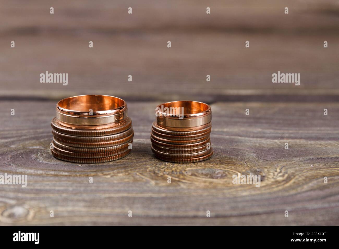 Pile di monete e anelli d'oro. Foto Stock