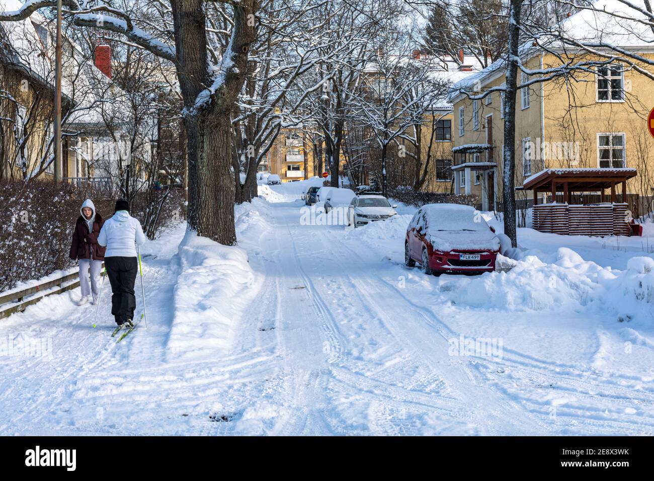 Donna che sciava lungo il marciapiede Tammitie nel distretto di Munkkiniemi di Helsinki, Finlandia Foto Stock