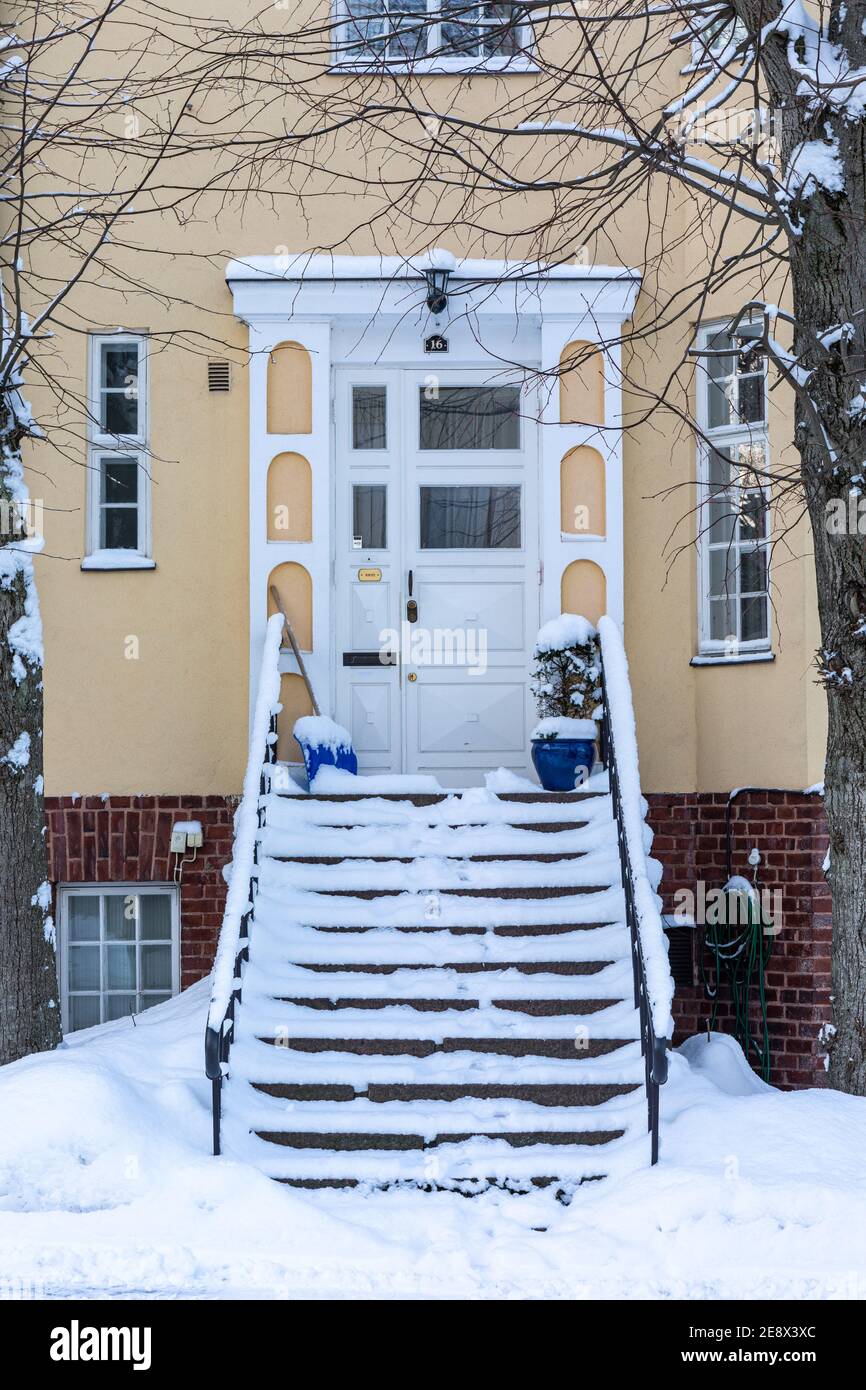 Scale coperte di neve di fronte a una casa a schiera progettata da Eliel Saarinen nel quartiere Munkkiniemi di Helsinki, Finlandia Foto Stock