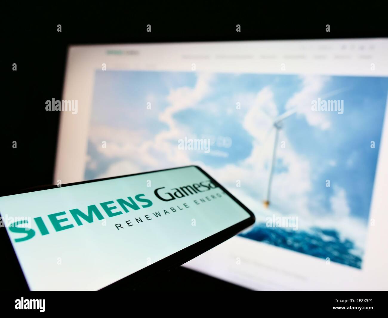 Smartphone con logo della società di ingegneria eolica Siemens Gamesa Renewable Energy S.A. in esposizione davanti al sito Web. Mettere a fuoco il centro dello schermo del telefono. Foto Stock