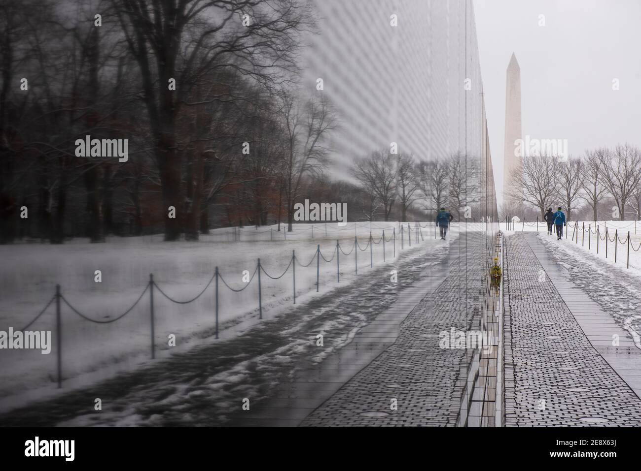 Una vista invernale del Vietnam Veterans Memorial durante una giornata innevata a Washington, D.C. il Washington Monument può essere visto in lontananza. Foto Stock