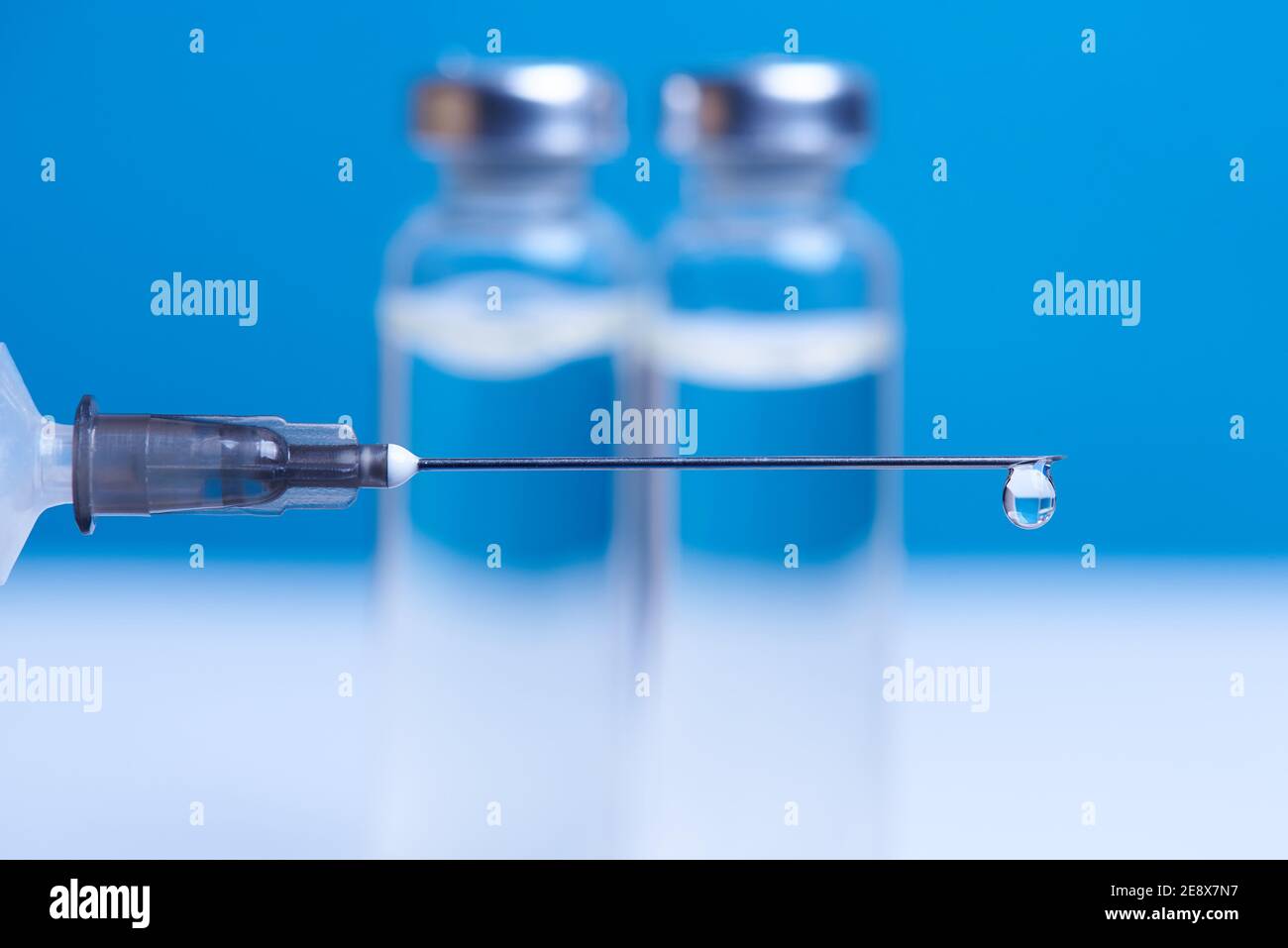 Ago della siringa con una goccia di vaccino in primo piano. Foto Stock