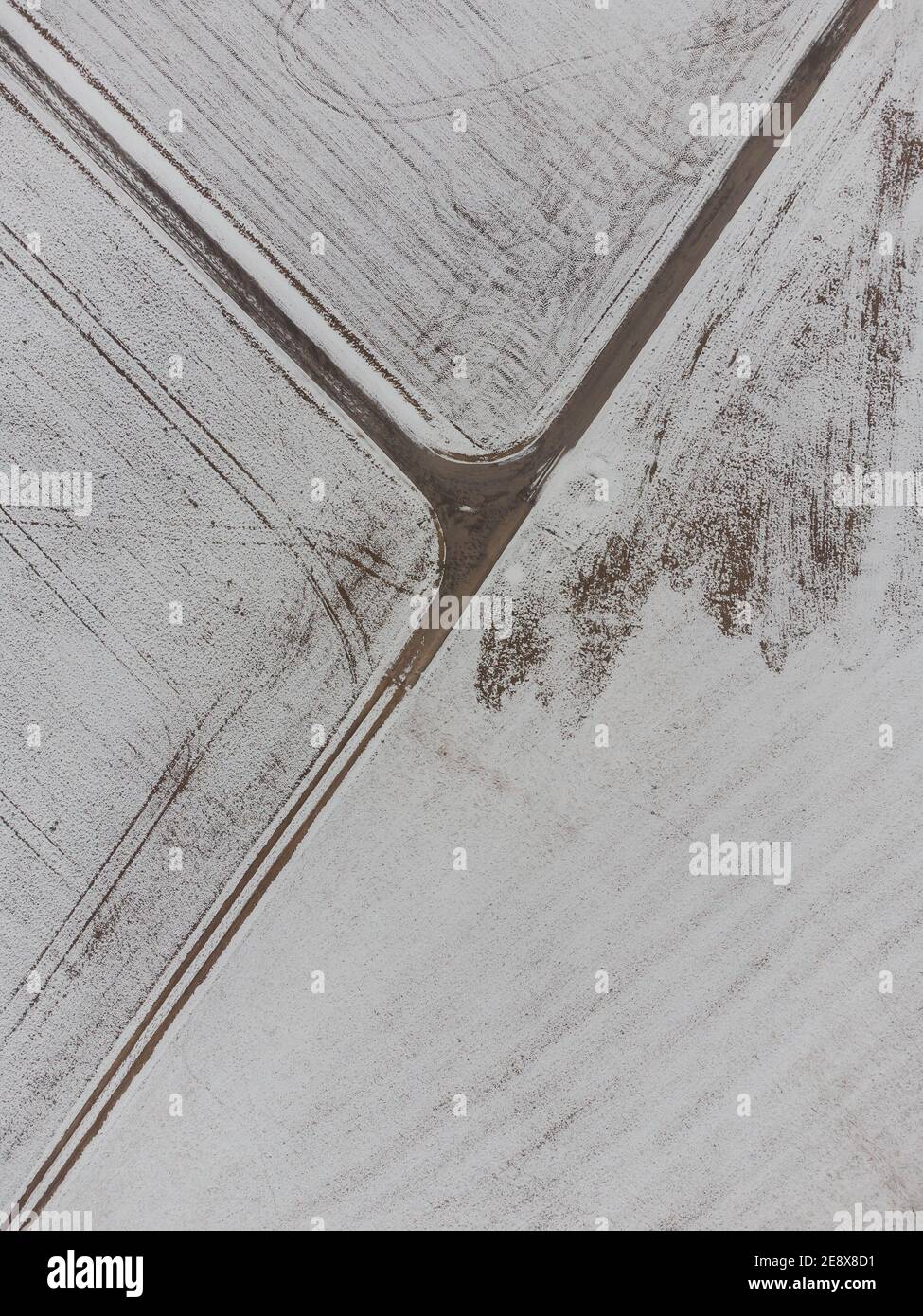 Immagine dall'alto verso il basso dell'intersezione a tre vie tra i campi in zona rurale in inverno con neve Foto Stock