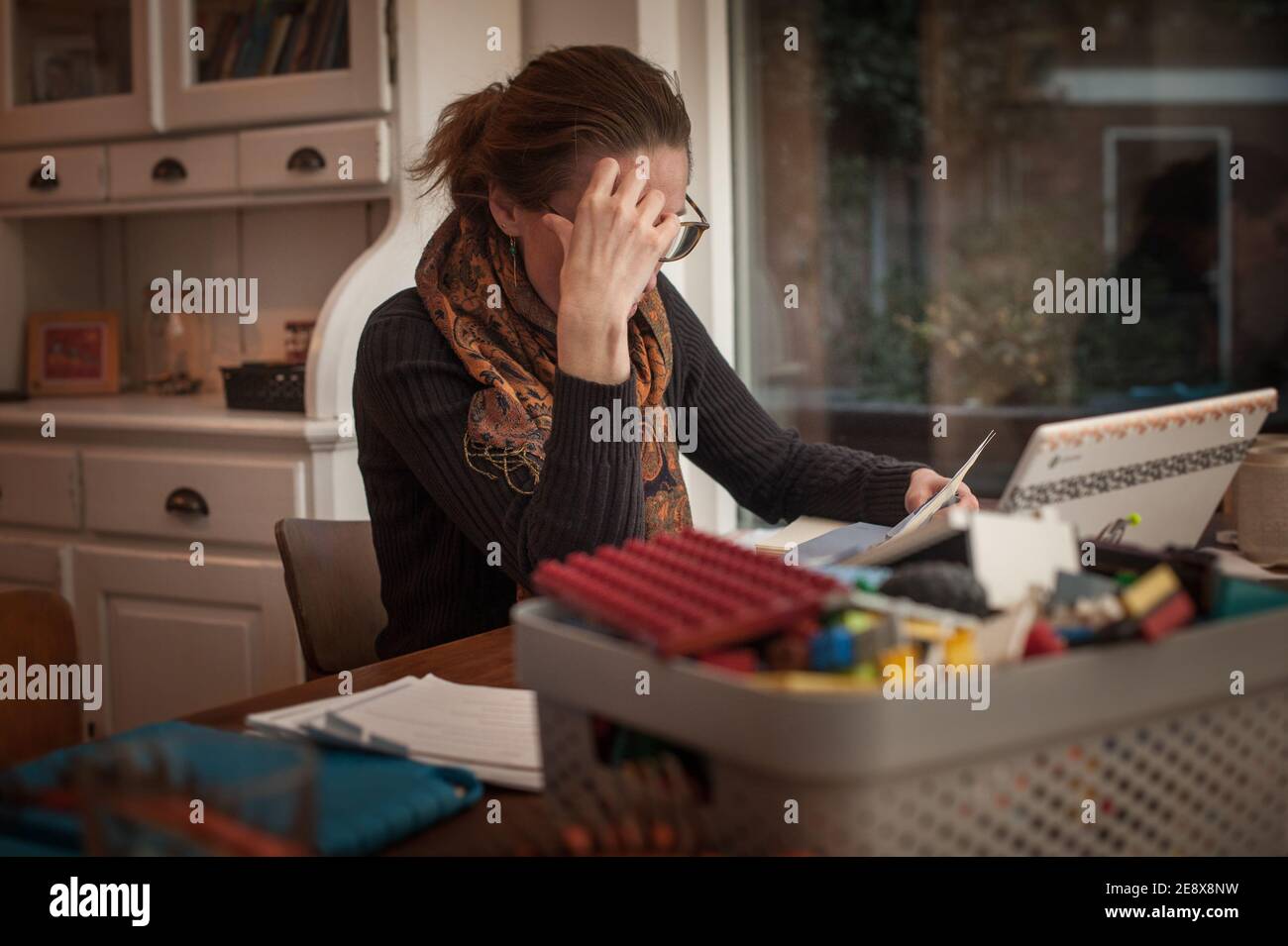 Una giovane donna con preoccupazioni finanziarie in un ambiente domestico sentirsi triste e sottolineato dalla sua situazione finanziaria Foto Stock
