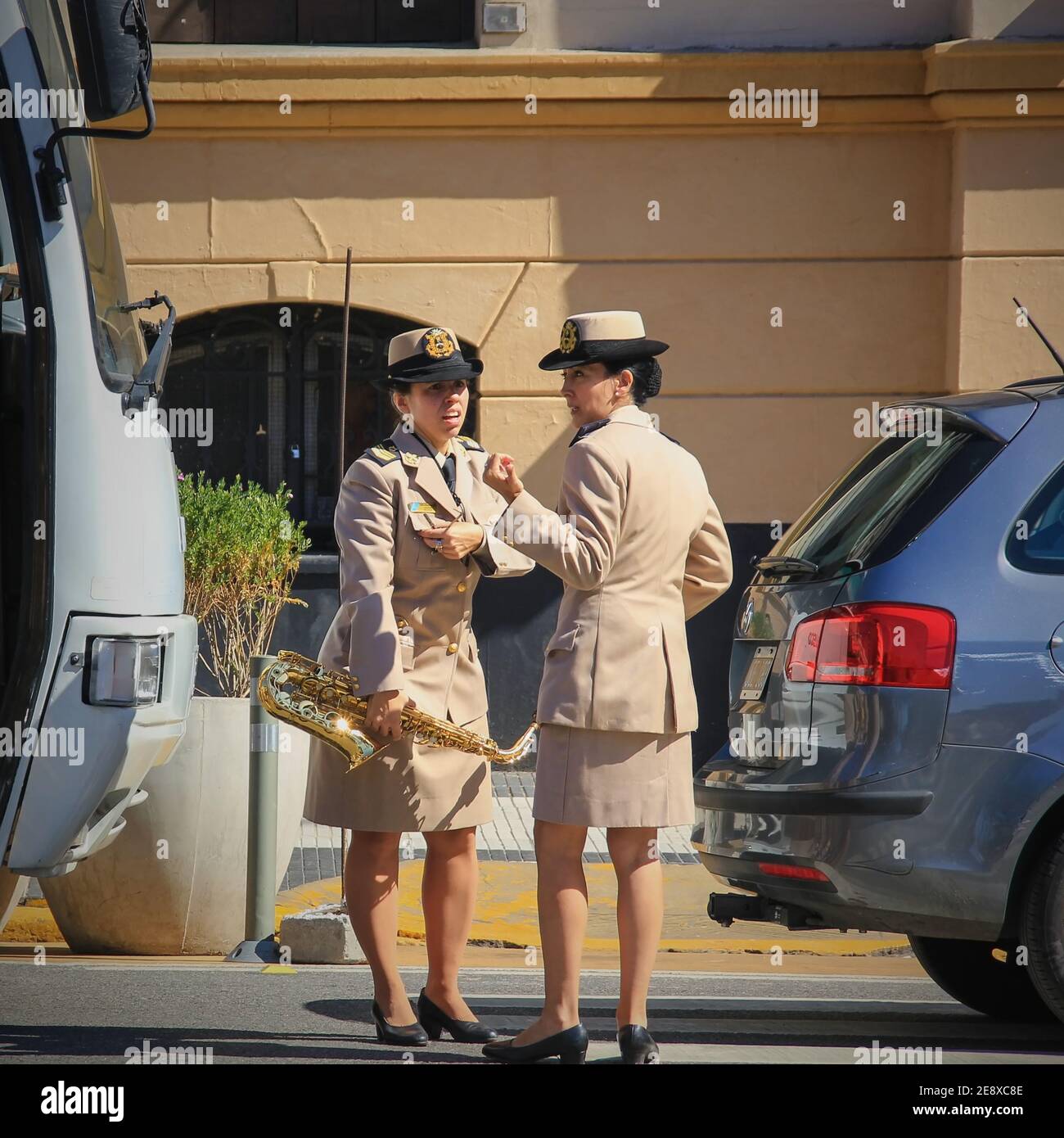 Due emozionanti musicisti ispanici vestiti in uniforme concerto gossiping chiacchierando sulle cose divertenti. Foto Stock