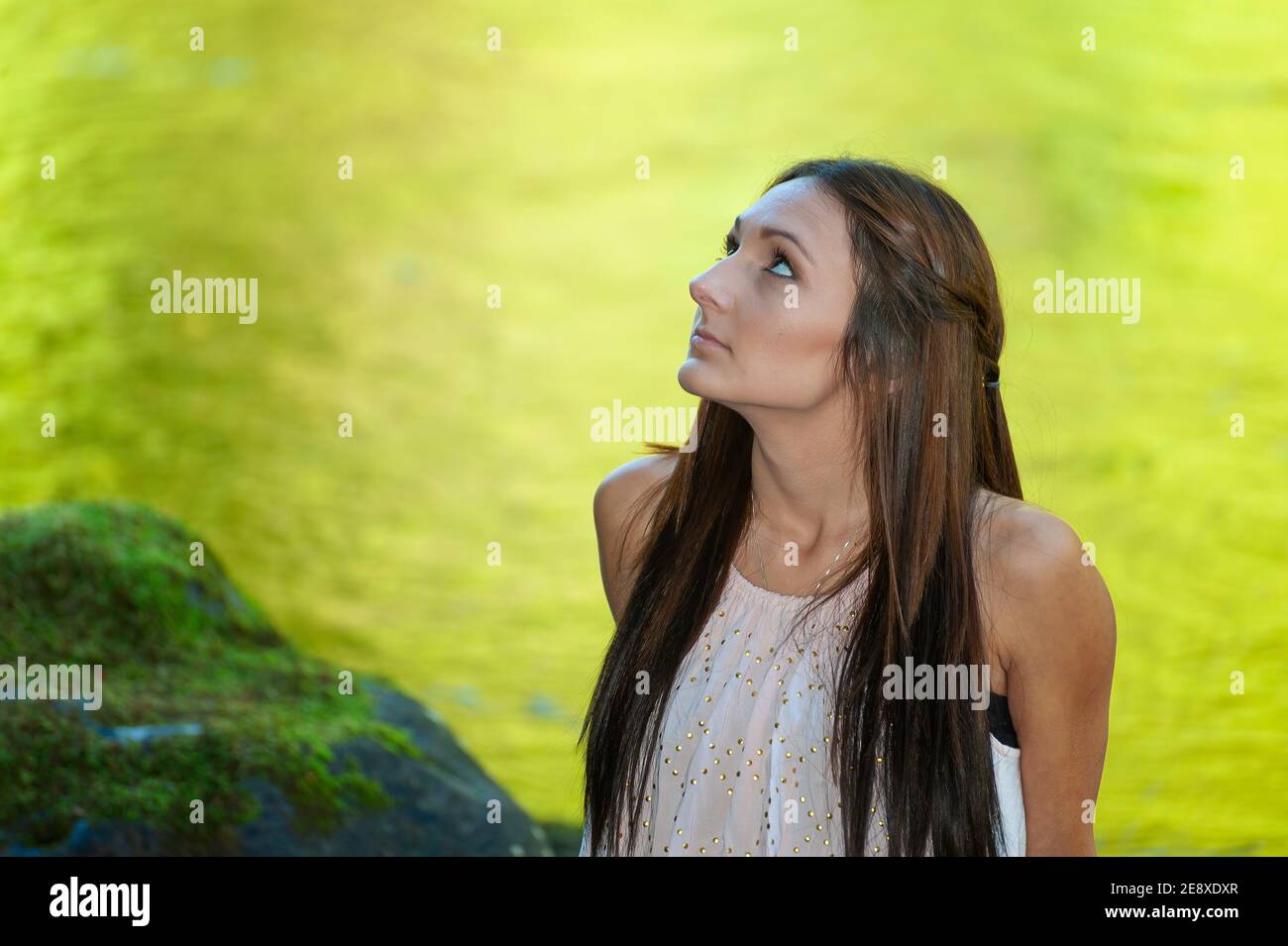 Una giovane donna si pone lungo le rive di un piccolo fiume. Foto Stock