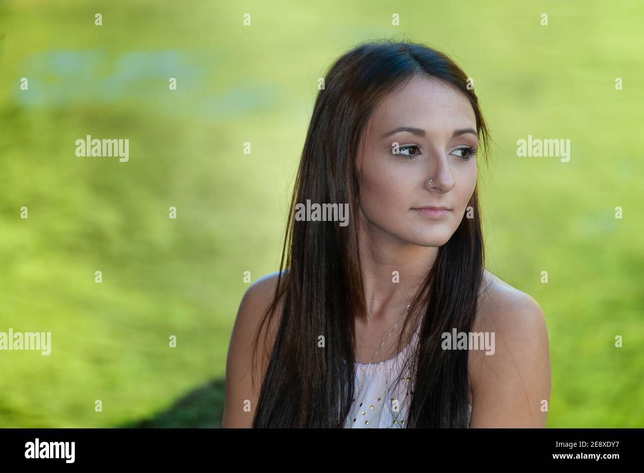 Una giovane donna si pone lungo le rive di un piccolo fiume. Foto Stock