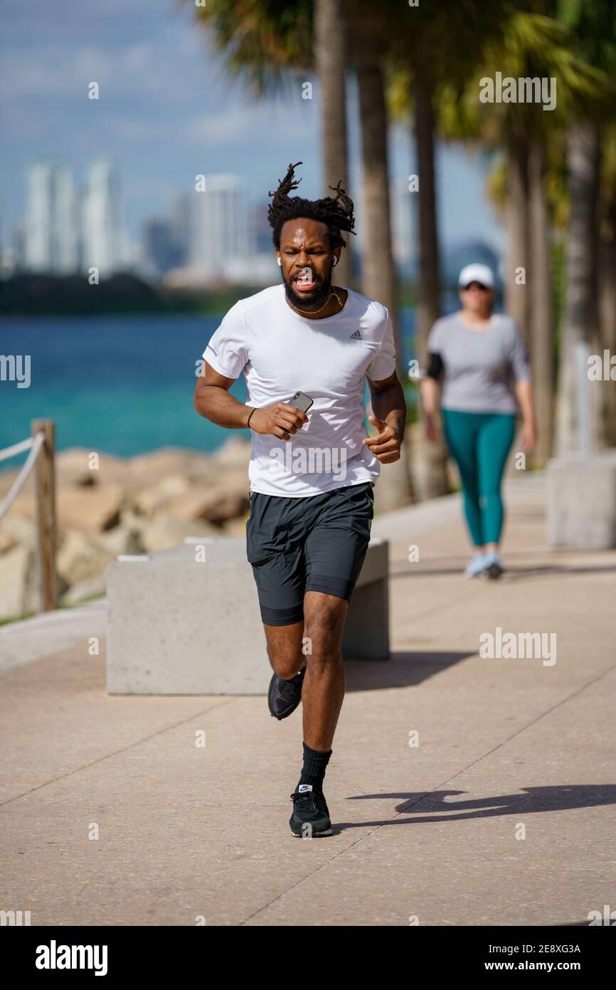 Uomo atletico che corre veloce grunting espressione facciale Foto Stock
