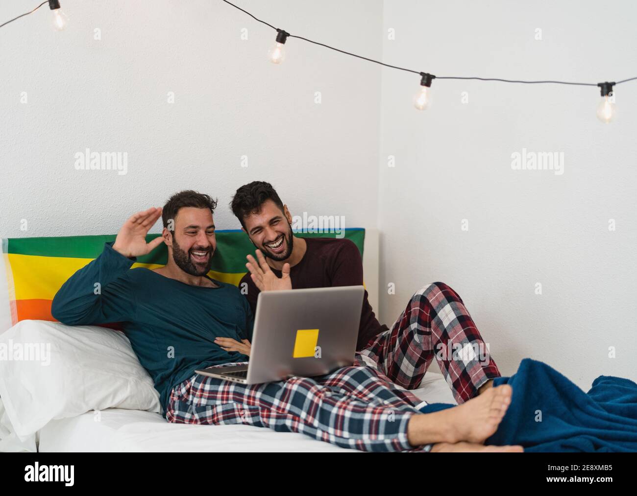 Happy gay uomini coppia fare videochiamata utilizzando il computer portatile all'interno Letto - amore omosessuale e uguaglianza di genere nel concetto di relazione Foto Stock