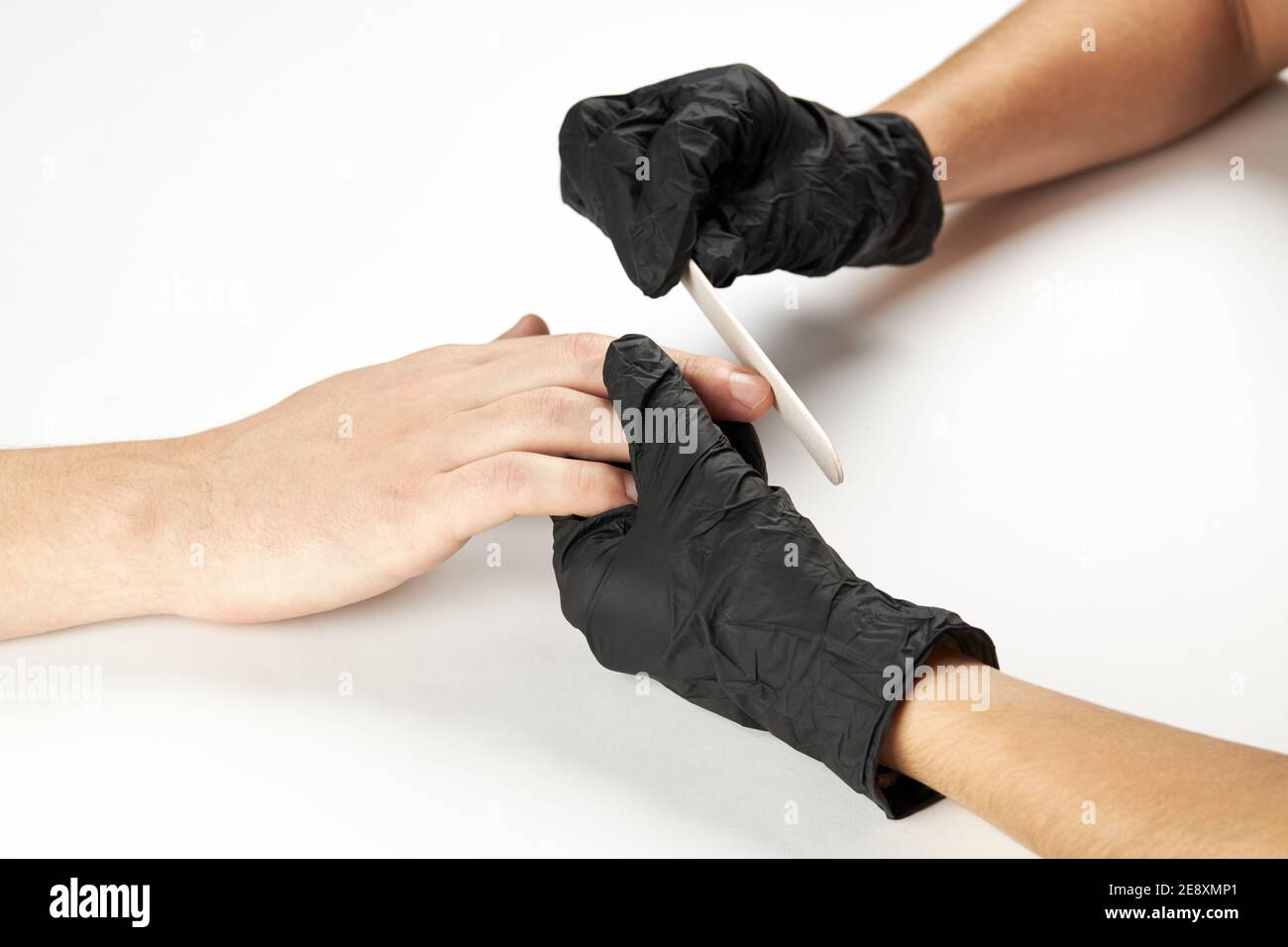 lavoro manicurista con lima del chiodo. un processo di manicure dell'uomo. una persona caucasica irriconoscibile che fa il servizio del chiodo al salone di cure estetiche. Foto Stock