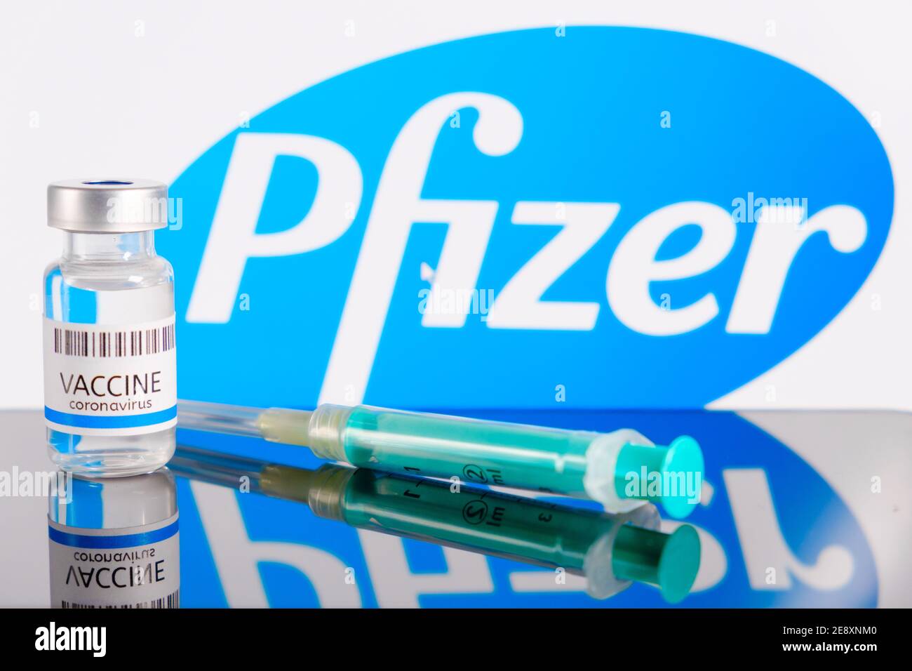 Logo Pfizer sullo sfondo del flacone o flaconcino con vaccino e siringa per iniezione per la prevenzione del coronavirus, SARS-COV-2, Covid-19, gennaio Foto Stock