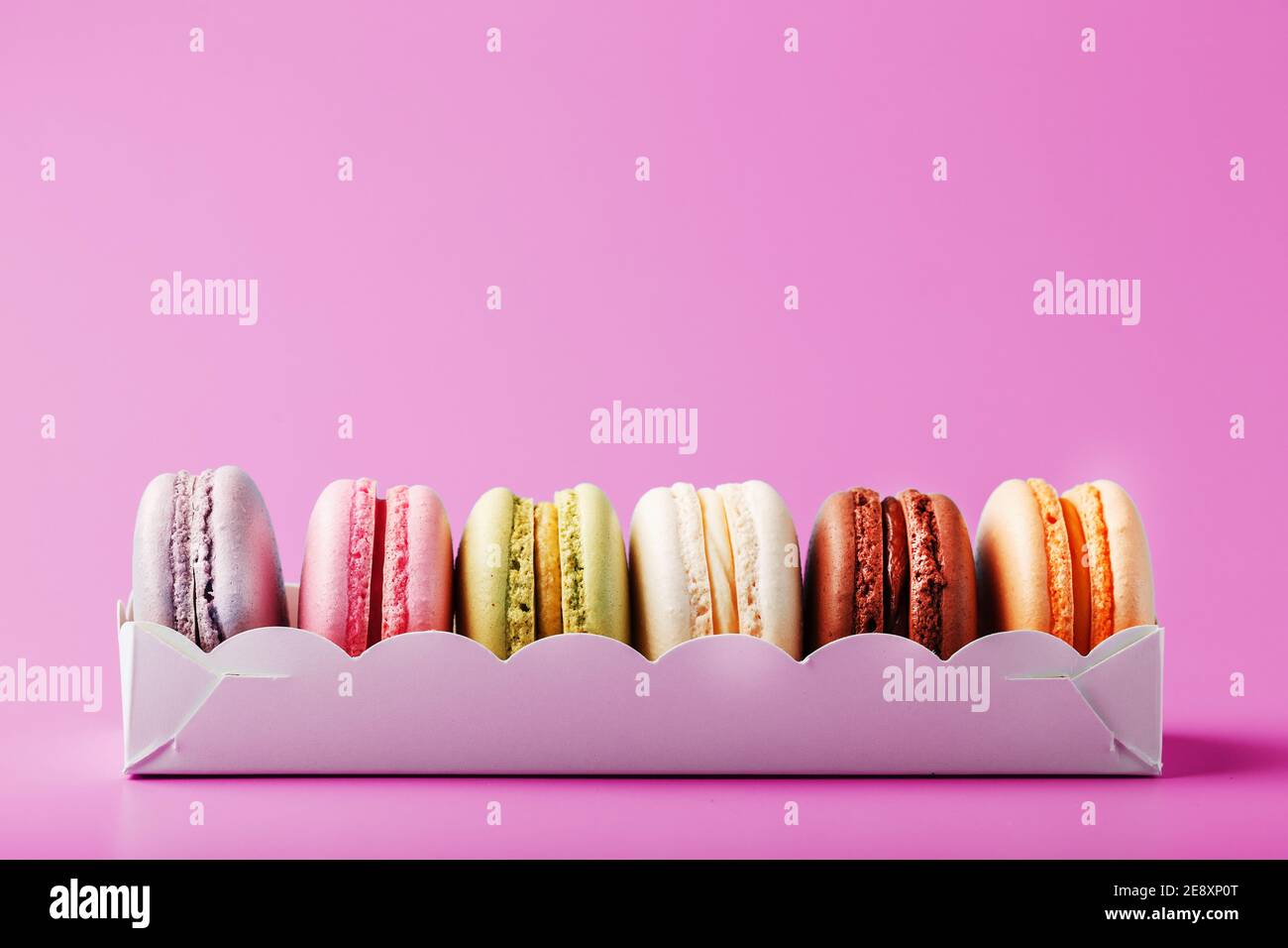 Biscotti colorati di macaron francesi in un pacchetto su sfondo rosa. Primo  piano, spazio libero Foto stock - Alamy