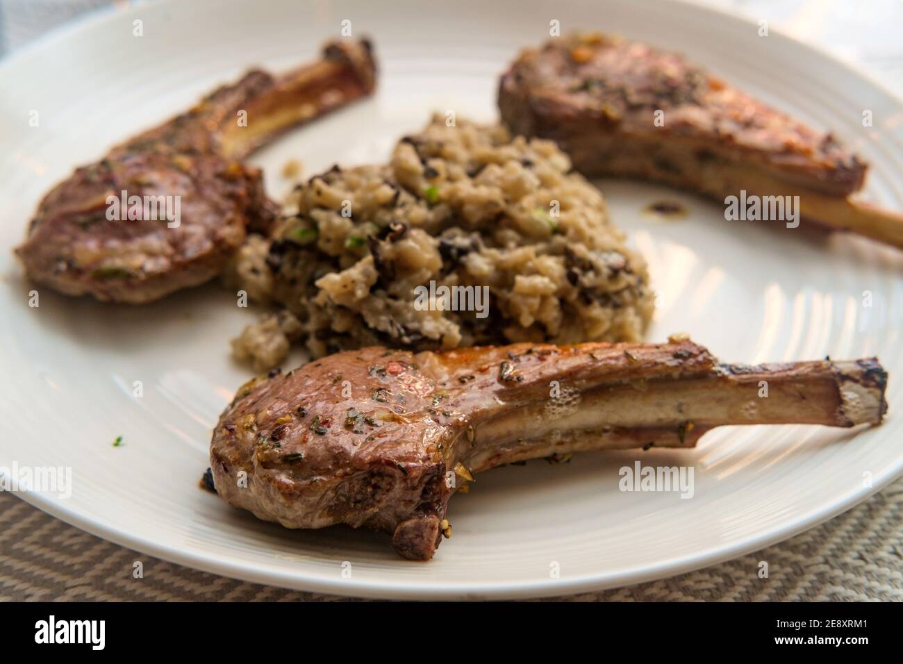 Costoletta di agnello marinata alla griglia con risotto di funghi cheesy Foto Stock