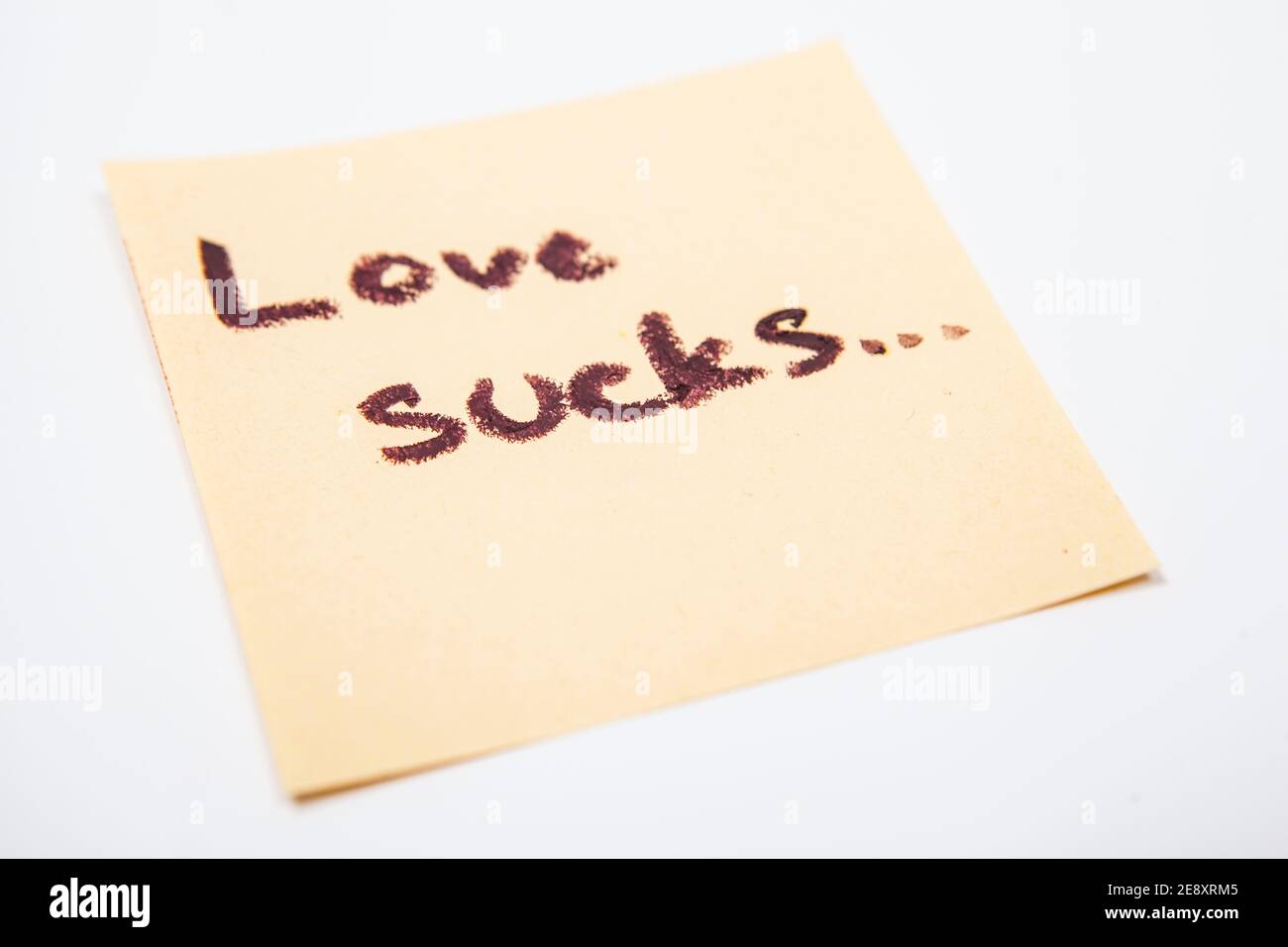 Primo piano di amore succhia nota scritta a mano su adesivo giallo carta Foto Stock