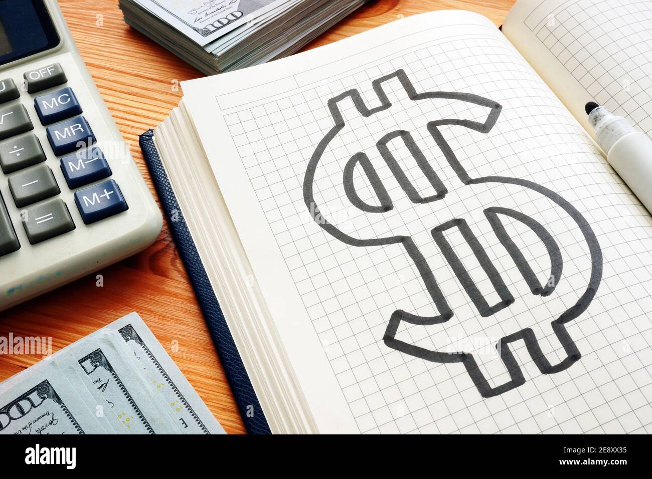 Simbolo del dollaro nel blocco note e una calcolatrice. Concetto di risparmio e ricchezza. Foto Stock