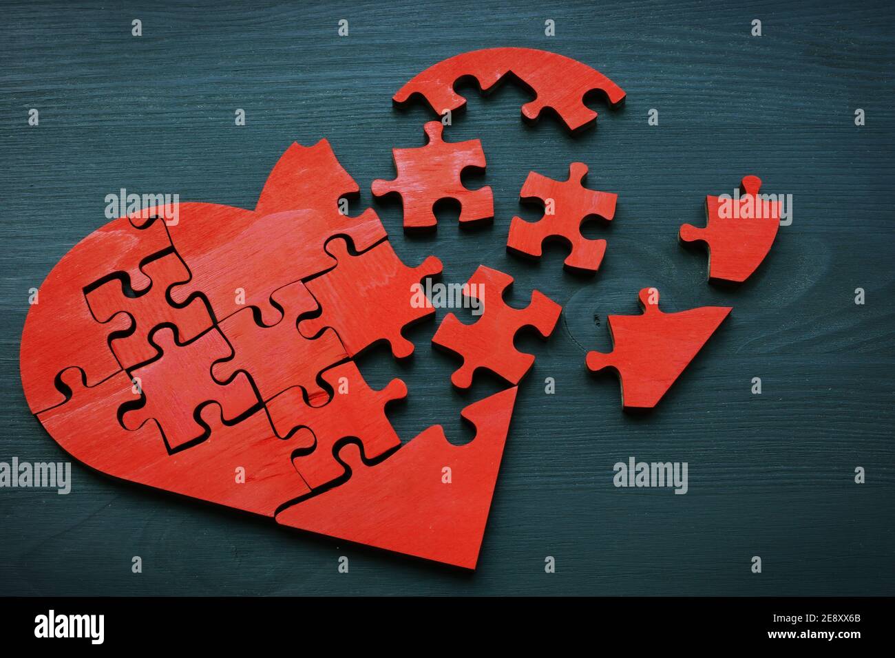 Un cuore rotto fatto da pezzi di puzzle come un simbolo di problemi di relazione. Foto Stock