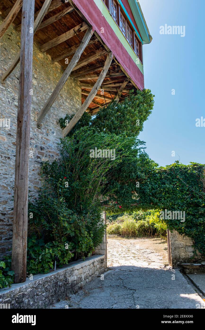 Felicità rigorosa. L'alto, solido muro di pietra senza aperture è più come un castello. Monastero di San Giorgio, Feneos, Corinzia, Grecia. Foto Stock