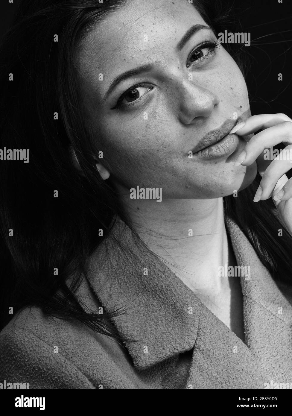 bel ritratto di una giovane donna, smrik, in posa in studio fotografico con sfondo bianco e effetto luce arcobaleno creato dal prisma. Foto Stock