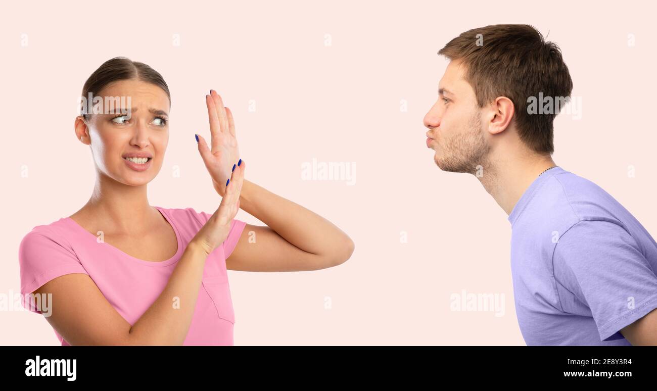 L'uomo che cerca di baciare la donna disgustata che lo respinge Foto Stock