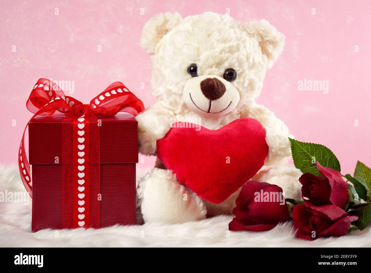 Happy San Valentino Teddy Bears with Love Hearts regali su sfondo in pelliccia rosa e bianca. Foto Stock