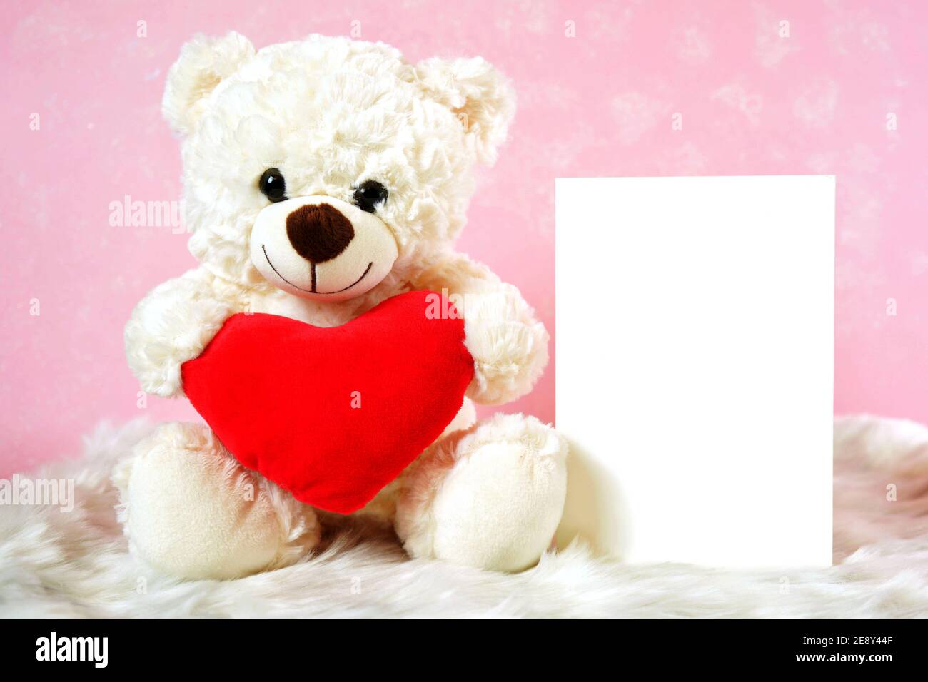 Happy Valentine's Day Bears with Greeting Card, rose rosse e regalo su sfondo di pelliccia rosa e bianca. Foto Stock