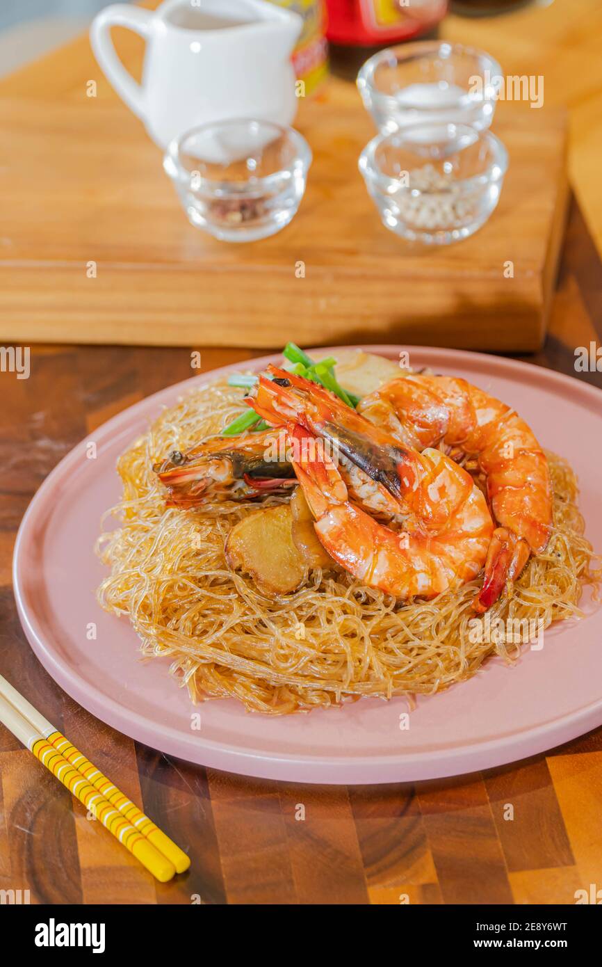 Gamberi al forno con tagliatelle di vetro, un tradizionale cibo tailandese avvolto in carta e bastoncini di freud trattati termicamente, pronti per essere serviti Foto Stock