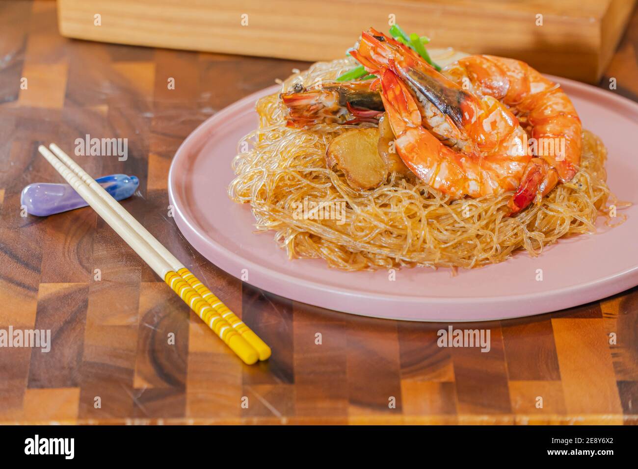 Gamberi al forno con tagliatelle di vetro, un tradizionale cibo tailandese avvolto in carta e bastoncini di freud trattati termicamente, pronti per essere serviti Foto Stock