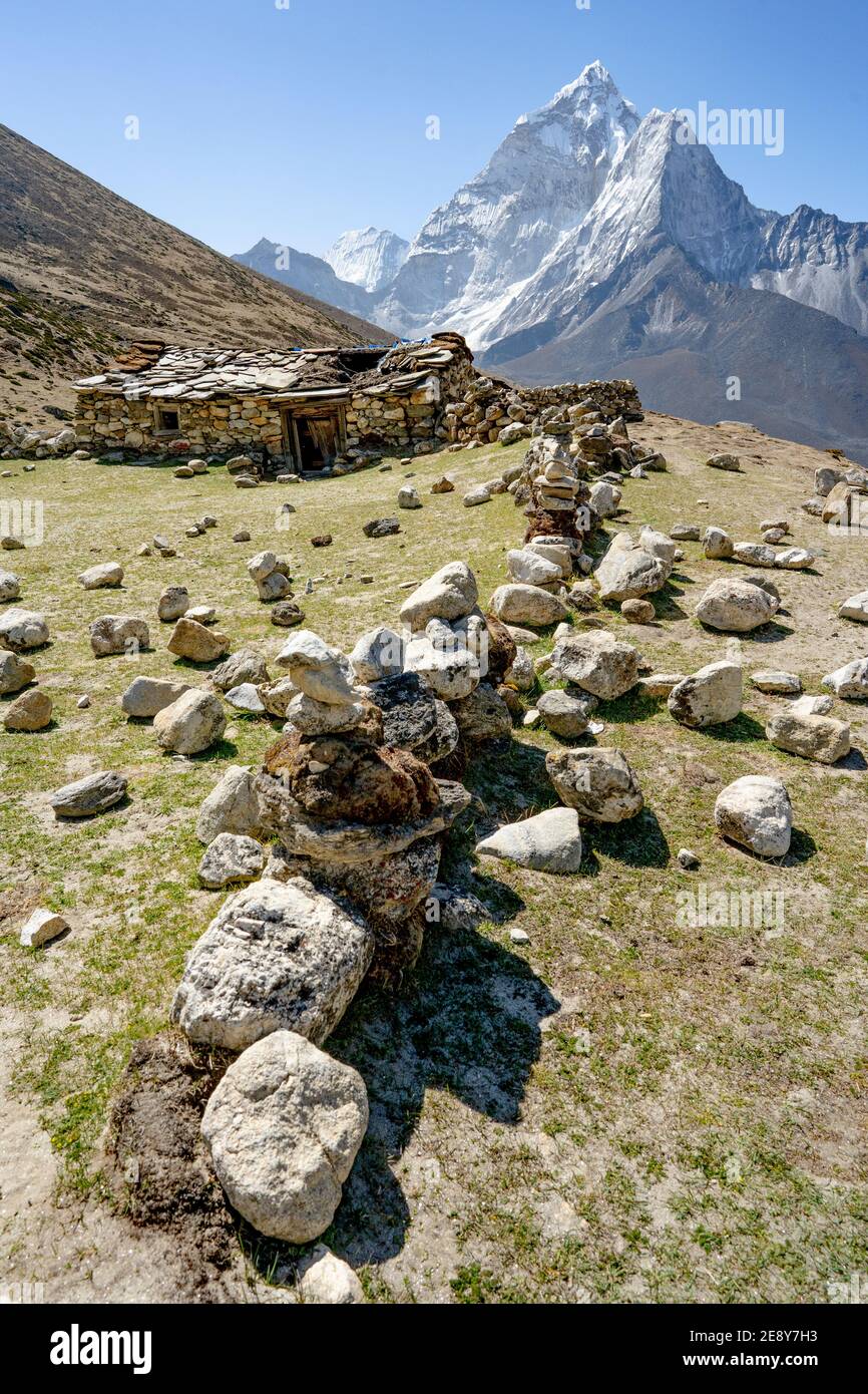 Casa di pietra all'ombra di ama Dablam, Himalaya, Nepal. Foto Stock