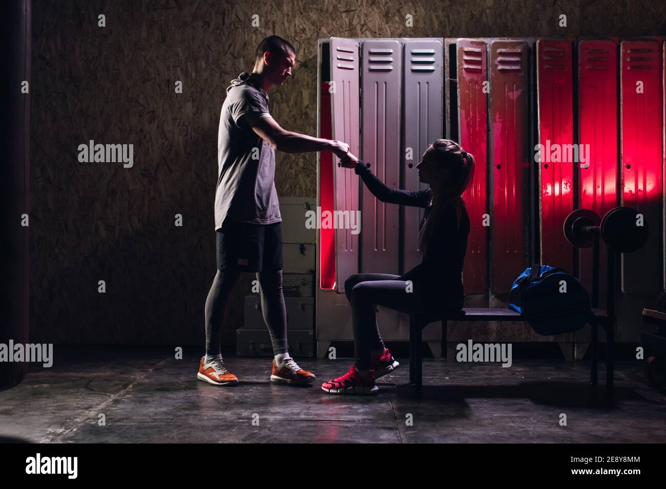 L'uomo e la ragazza si preparano per l'addestramento di boxe nel spogliatoio Foto Stock