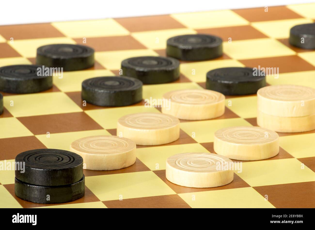 dama o bozze è un gioco da tavolo. Primo piano di scacchi rotondi in legno. Sfondo bianco. Foto Stock