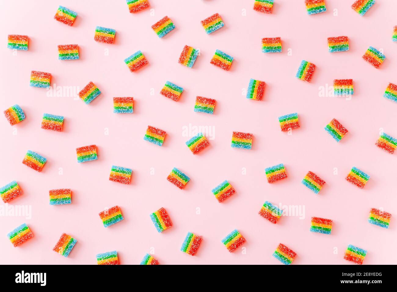 Arcobaleno succosa gummy candie sfondo. Modello da dolci di gelatina su sfondo rosa Foto Stock