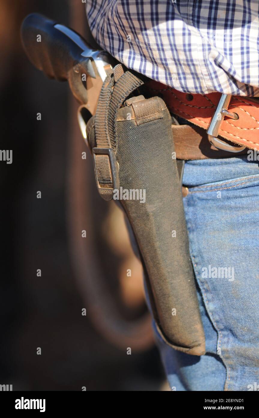Un primo piano di un cowboy, la rivolta coperta di polvere in una fondina. Foto Stock