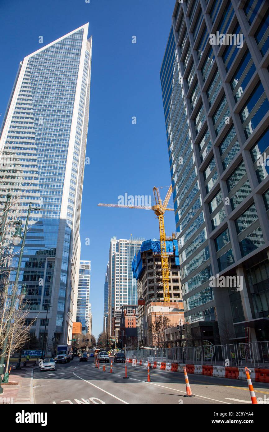 Una vista di S. Tryon Street nel centro di Charlotte, Carolina del Nord, con moderni edifici per uffici e costruzioni edili. Foto Stock