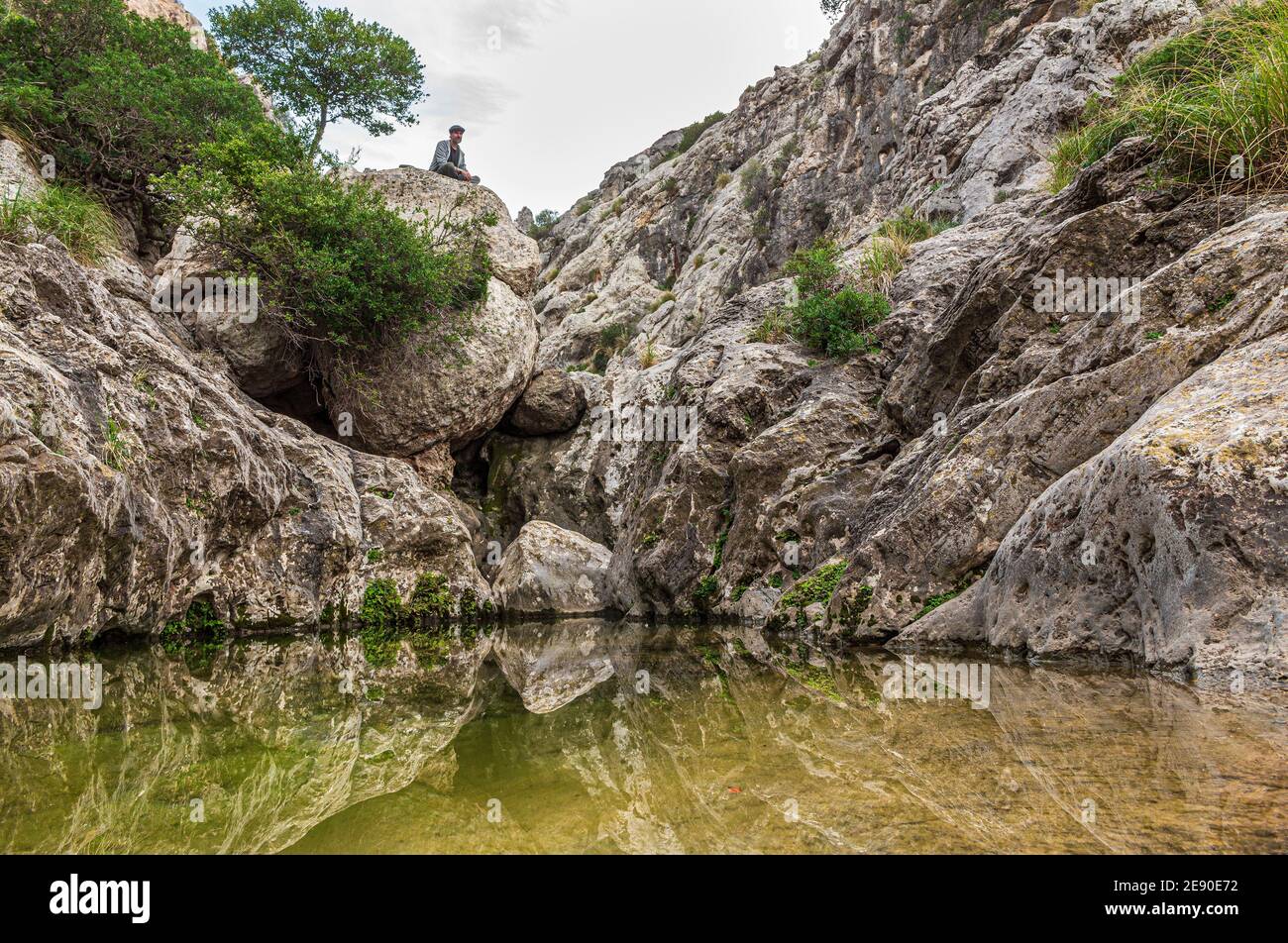 Trekker relax sopra la montagna. Torrente di Mortitx. Serra de Tramuntana. Isola di Maiorca. Spagna. Foto Stock